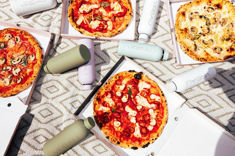 Waterflessen kopen die RVS liggen op een kleed in een park