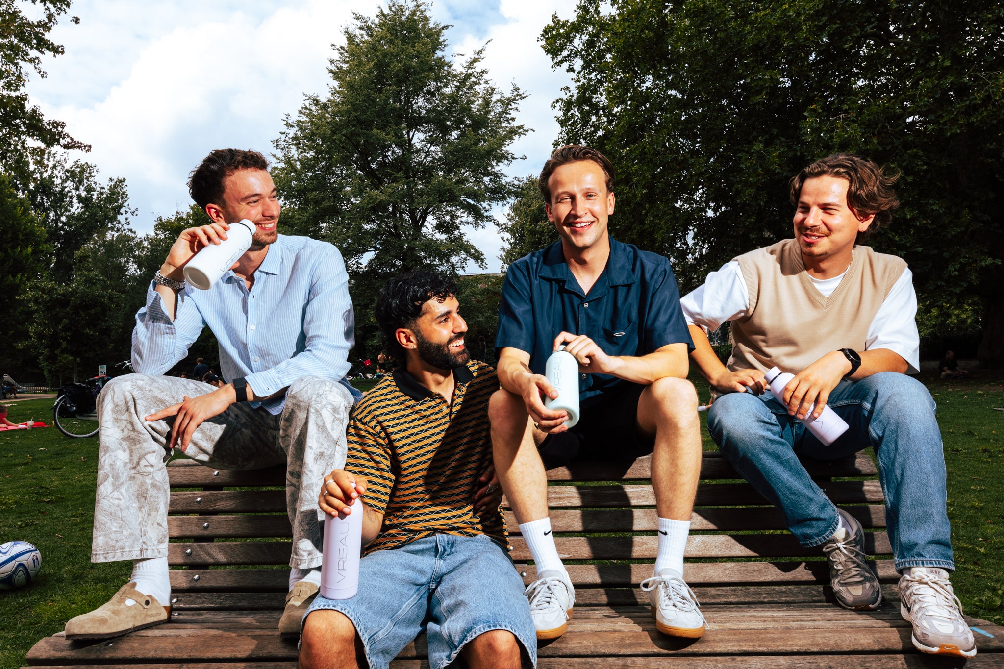 Vier mannen genieten buiten met Vireau RVS drinkflessen – Service en Support voor duurzame keuzes.